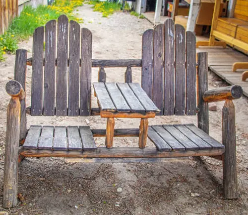 Rustic wooden bench with a small table in the center, made from reclaimed wood.