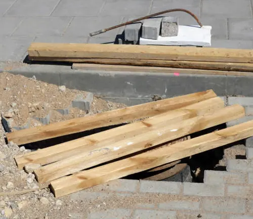 Timber strips placed on the ground, ready for use in construction or flooring projects.