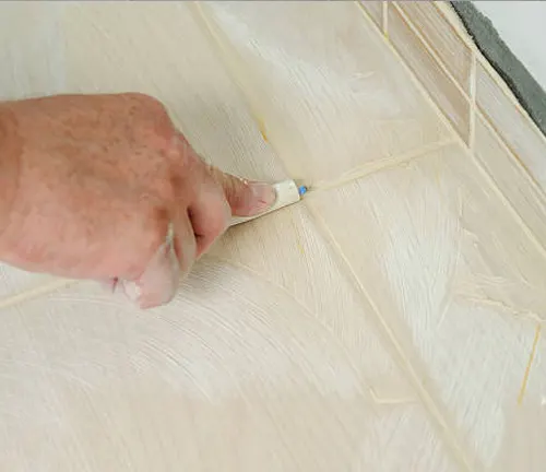 Applying wax filler into gaps of timber flooring to create a smooth, seamless finish.