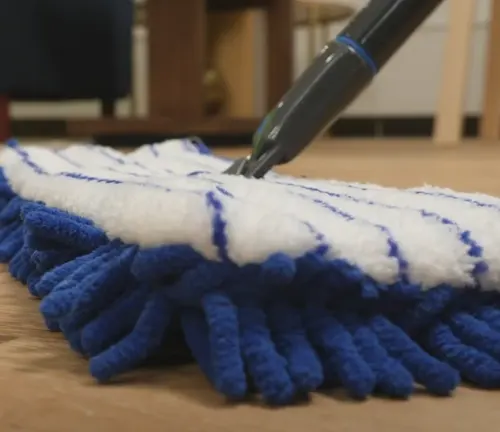 Microfiber mop cleaning wooden floor, designed for dust removal without scratching the surface.