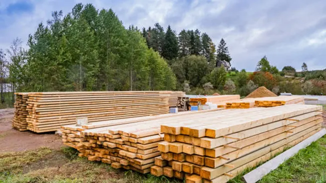 Stacks of timber stored on a flat, elevated surface to prevent moisture damage.