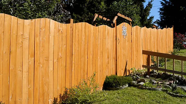 Six foot wooden privacy fence providing security and seclusion in a beautifully landscaped yard.