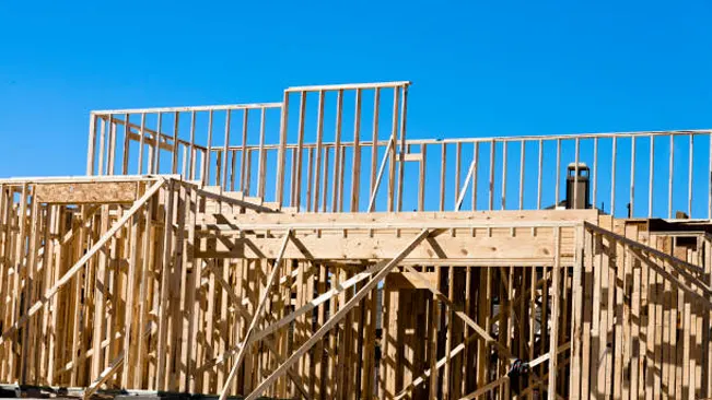 Wooden framing of a building under construction, highlighting the use of lumber in construction.