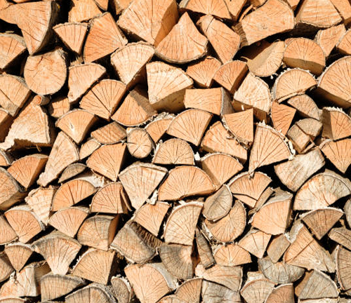 A tightly stacked pile of neatly cut firewood, showcasing the even texture and growth rings of the wood, ready for use in heating or woodworking projects.