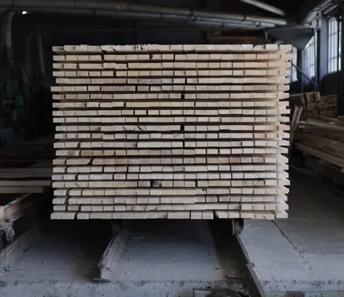 Stacked lumber in a kiln, undergoing controlled drying with heat and airflow for consistent moisture reduction.