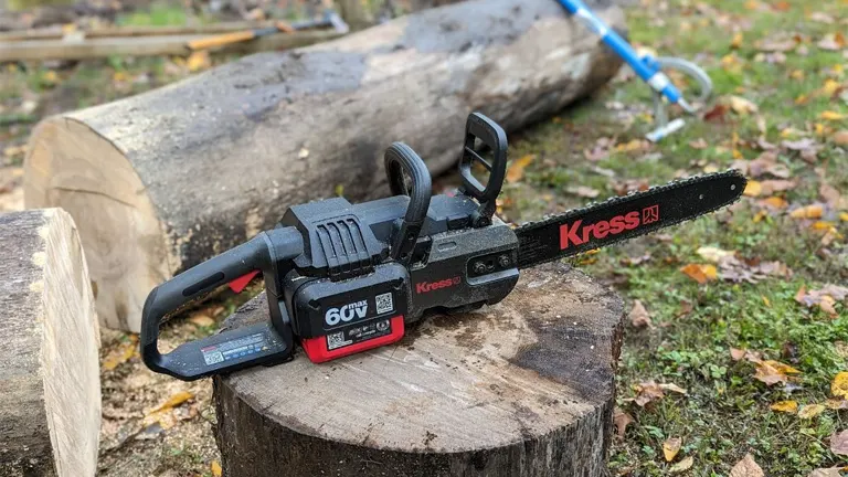 Kress Commercial 60V 14-inch top-handle chainsaw placed on a tree stump outdoors, showcasing its design and rugged build for professional use.