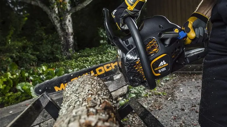 McCulloch CS 35S Petrol Chainsaw cutting a log outdoors.