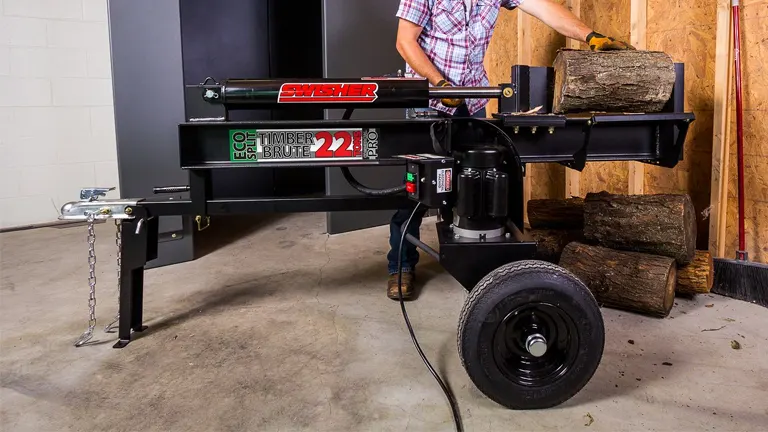 Person using Swisher LS22E log splitter to split firewood indoors.