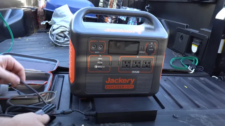 Jackery Explorer 1500 solar generator placed in a truck bed, with cables being connected for charging or usage.