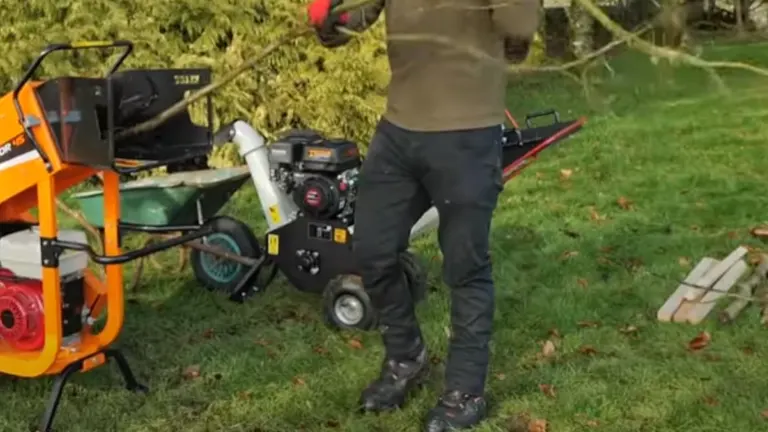 Person feeding a branch into the Ingco WCS350 Gasoline Wood Chipper.