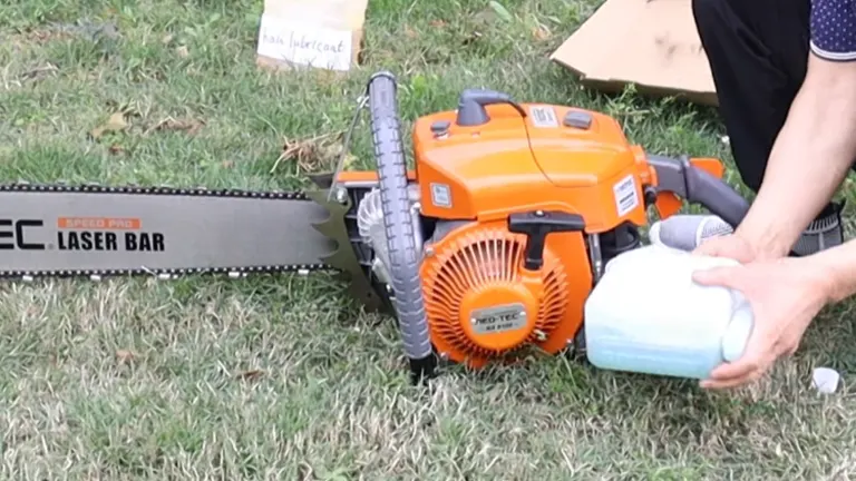 NeoTec NS8105 gas chainsaw on grass with lubricant bottle next to it.