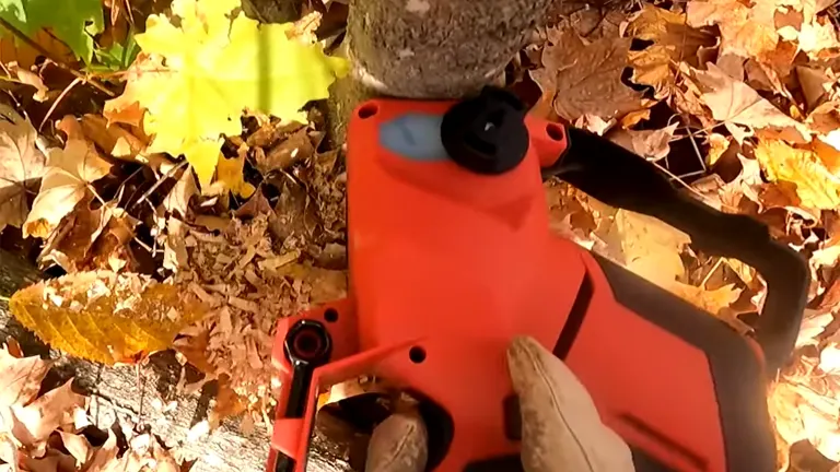 Person using a Milwaukee M18 FUEL mini chainsaw to cut a tree branch, viewed from above, surrounded by autumn leaves.