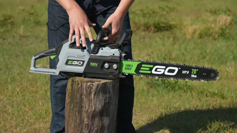 Person adjusting the EGO Power+ CS2005 20-inch Cordless Chainsaw resting on a tree stump outdoors.