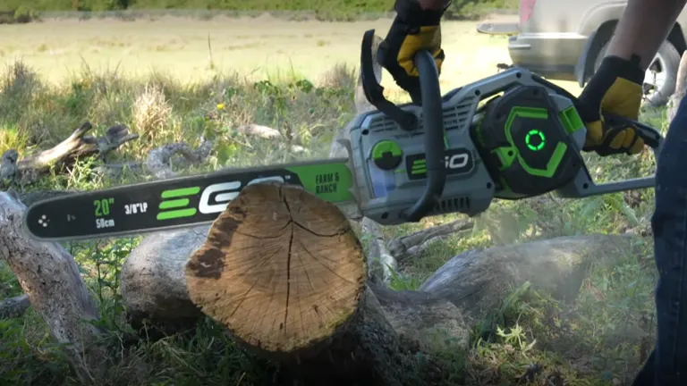 User cutting a log with the EGO Power+ CS2005 20-inch Cordless Chainsaw outdoors.