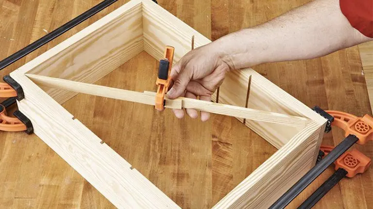 Clamped wooden frame with rabbet joints being aligned and secured.