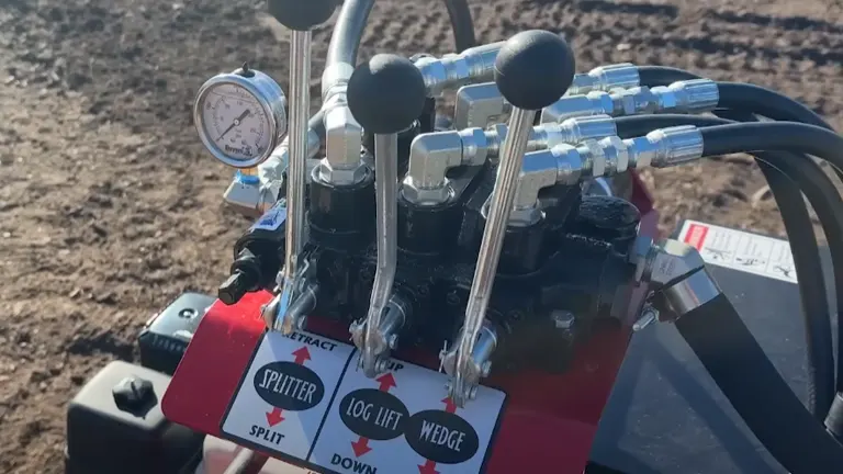 Close-up of control levers on Wolfe Ridge 28 Pro Log Splitter with splitter, log lift, and wedge settings.