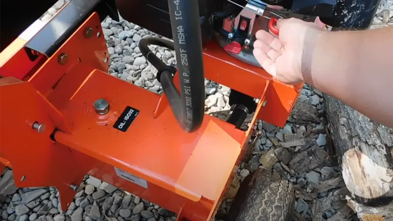 Hand operating the controls of the Ariens 22 Ton Log Splitter.