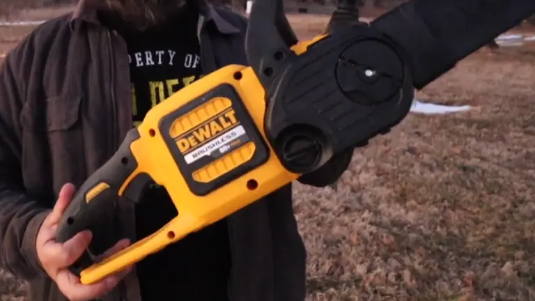 User holding the Dewalt DCCS670T1 Flexvolt Brushless Chainsaw, showing the battery compartment and side view.